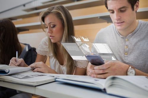 Serious college student working on futuristic smartphone in lecture hall-1